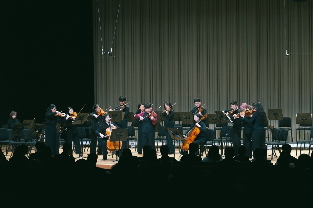 small group of youth playing violins and cellos on stage