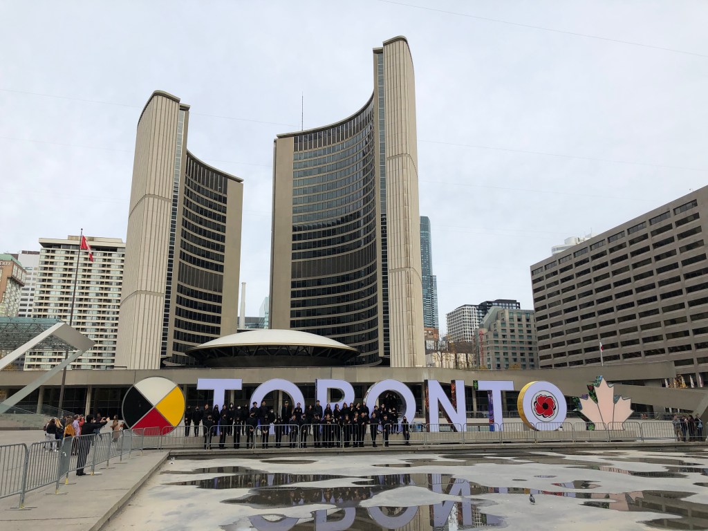 Group photo in front of Toronto City Hall after a volunteer performance. 